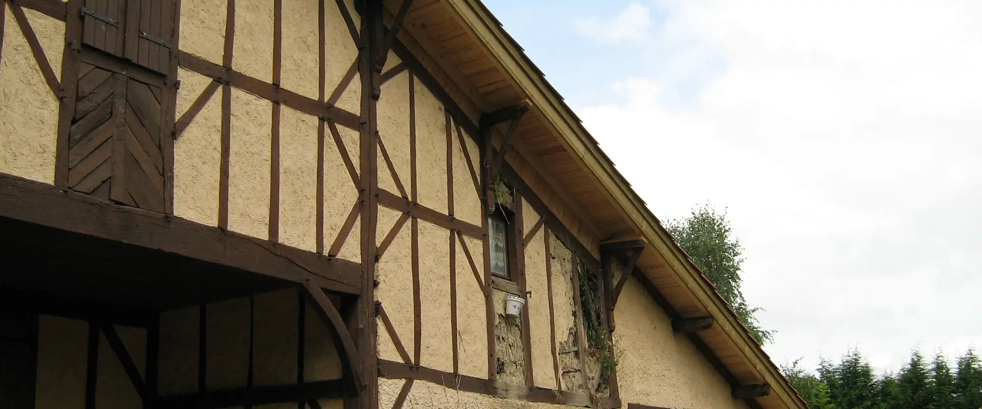 Façade à pans de bois d'un bâtiment ancien landais, enduit dégradé entre les colombages