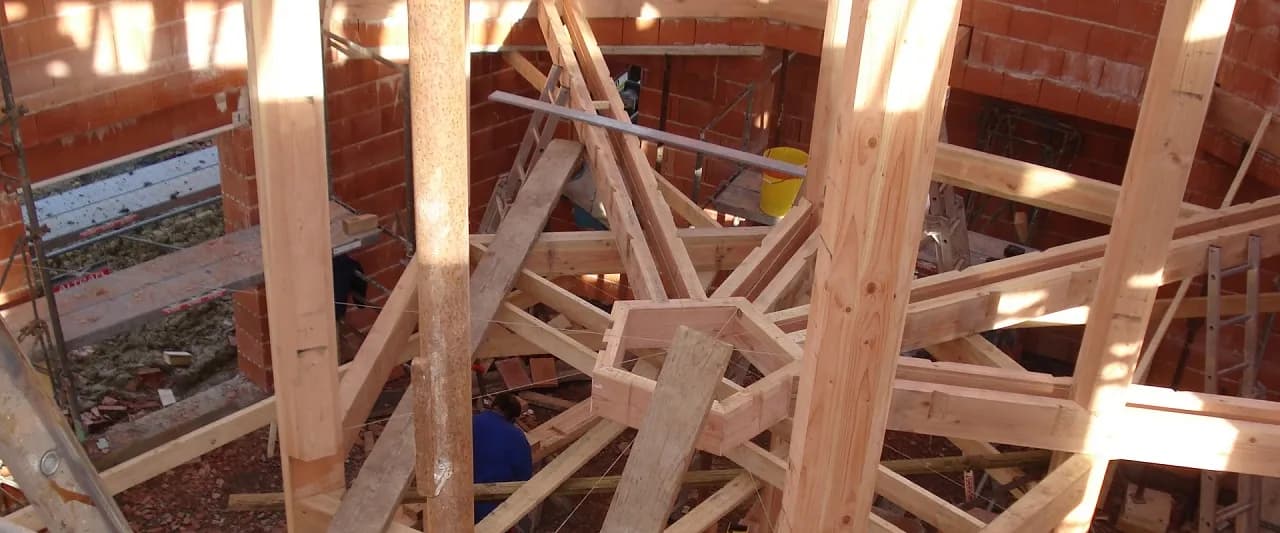 Charpente traditionnelle en cours de montage dans une maison en construction