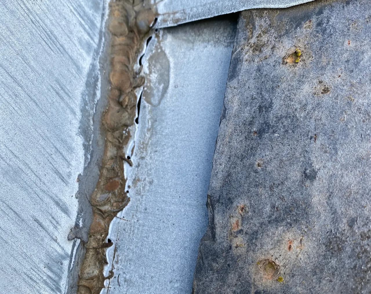 Soudure défaillante entre deux éléments de zinc sur une couverture métallique